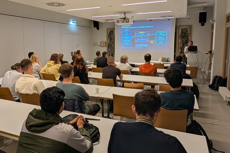 The audience following a system diagram during the third talk