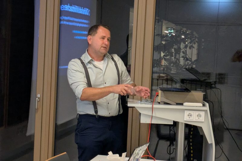 Christian Klimbacher taking a live measurement with multimeter probes on stage